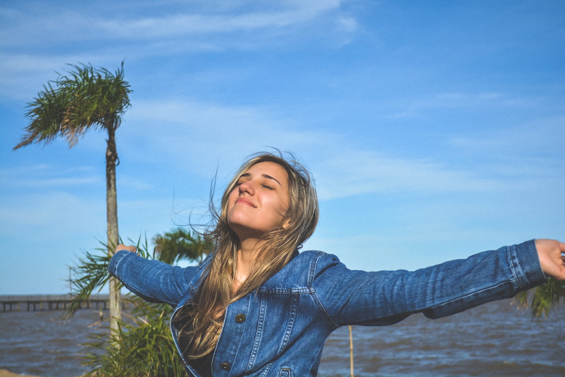 Image of a beautiful woman with her arms outstretched, embracing the fresh breeze.